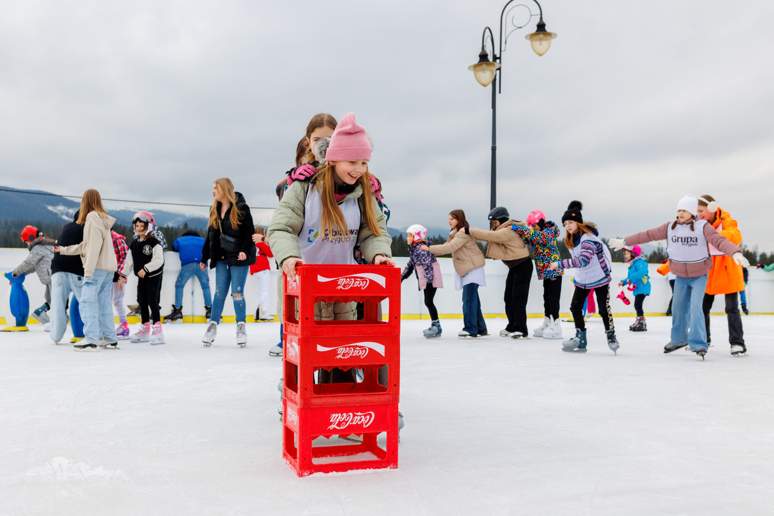 Dzieci bawiące się na lodowisku na zimowym obozie