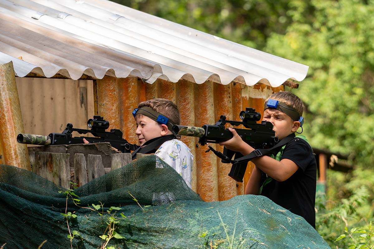 Używanie karabinów podczas zabaw na obozie survivalowym